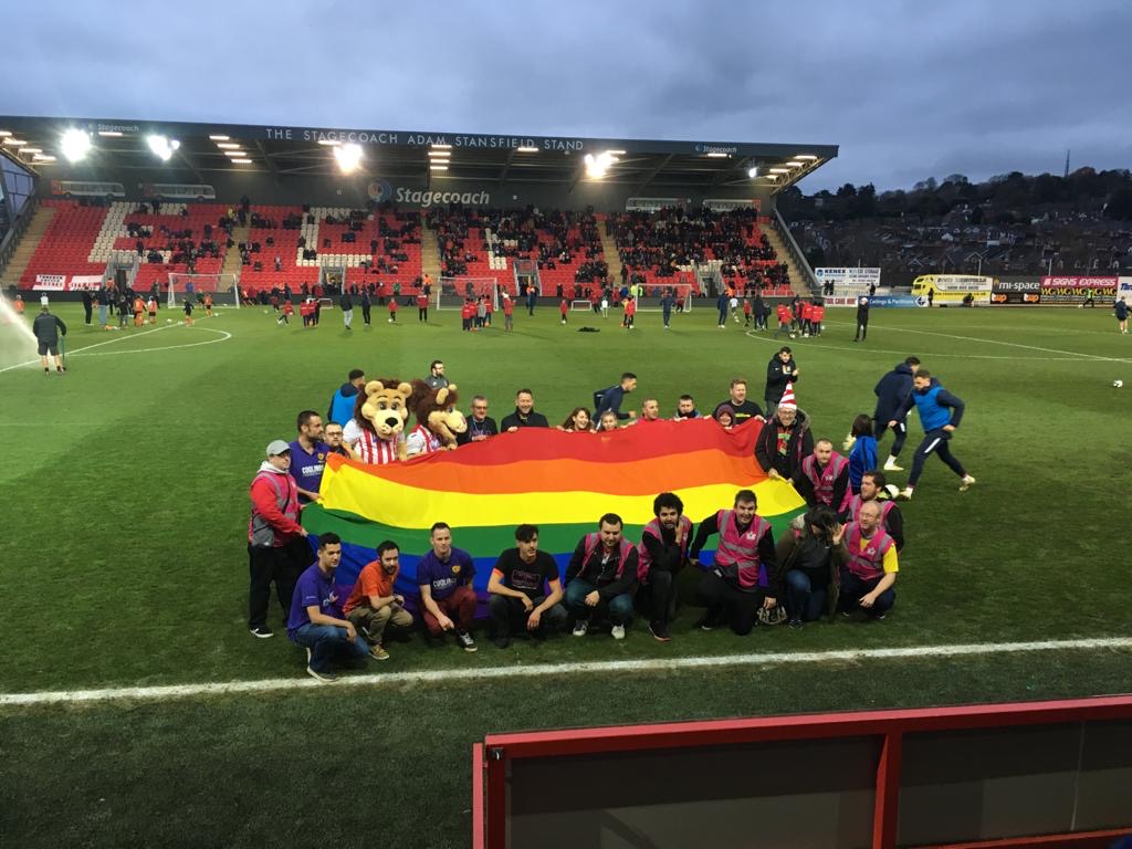 The flag being carried around the pitch at half-time at St James' Park, Exeter.JPG
